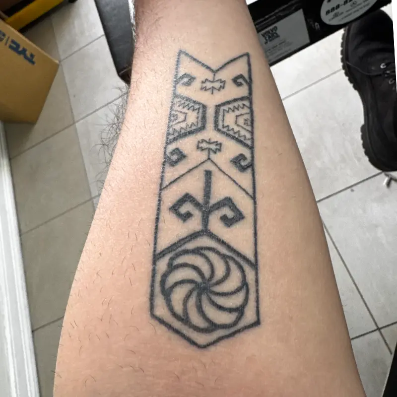 Geometric outline tattoo of Armenian carpet motifs and an eternity sign on the forearm, by Andres at Killer Silver Tattoo