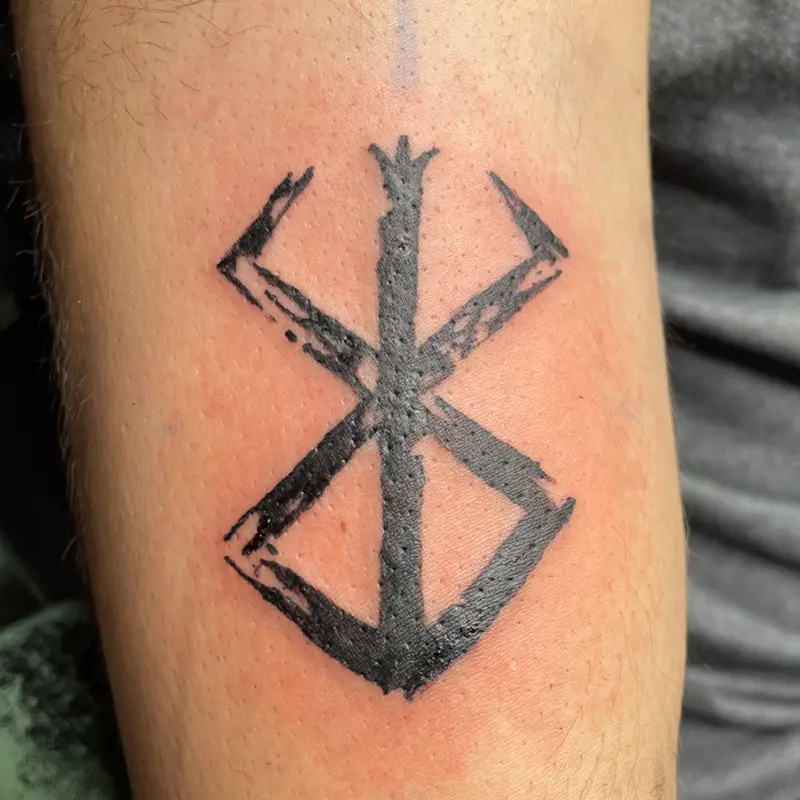 Blackwork tattoo of the Brand of Sacrifice from Berserk in brushstroke lines on the arm, by Andres at Killer Silver Tattoo