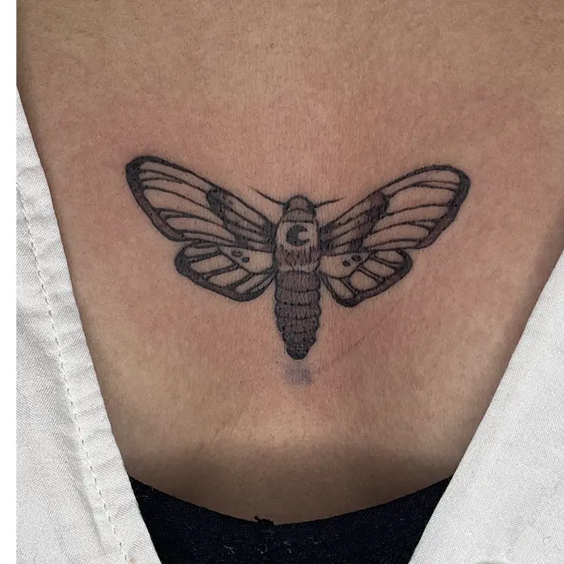 Black and gray death's-head moth tattoo with crescent moon detail on chest — Killer Silver Tattoo Studio