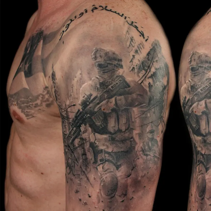 Black and gray realism half sleeve of a US Marine in combat gear marked RONIN, with an American flag chest panel and Arabic script