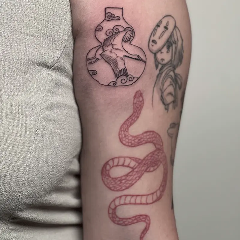 Fine-line tattoo collection on forearm featuring a crane-and-vase design, a character portrait, and a coiled snake — Killer Silver Tattoo Studio