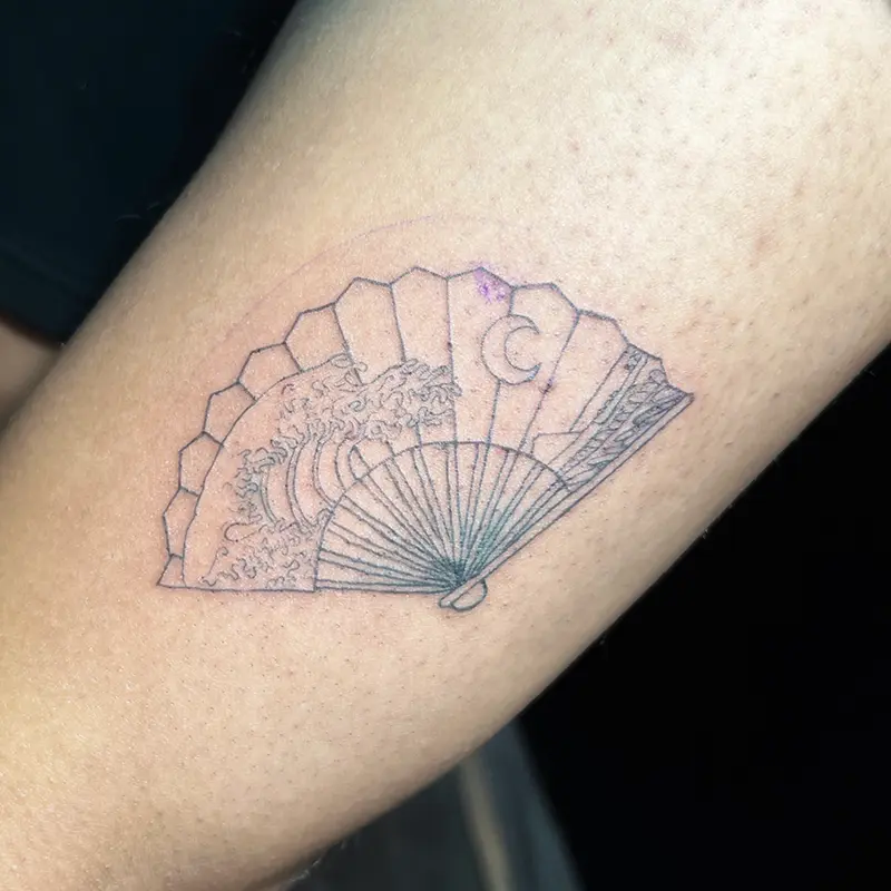 Fine-line folding fan tattoo with wave and crescent moon design on forearm — Killer Silver Tattoo Studio