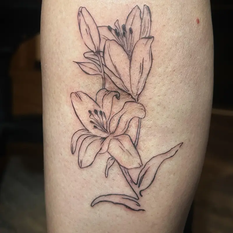 Fine-line lily flower tattoo, black outline, on calf — Killer Silver Tattoo Studio