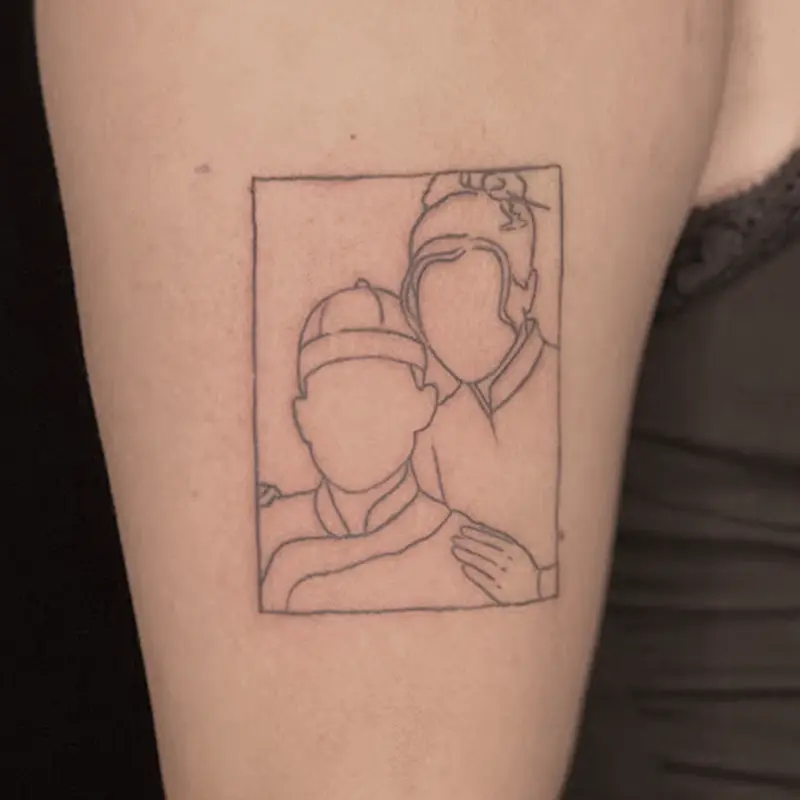 Fine-line framed couple portrait tattoo, faceless silhouette style, on upper arm — Killer Silver Tattoo Studio