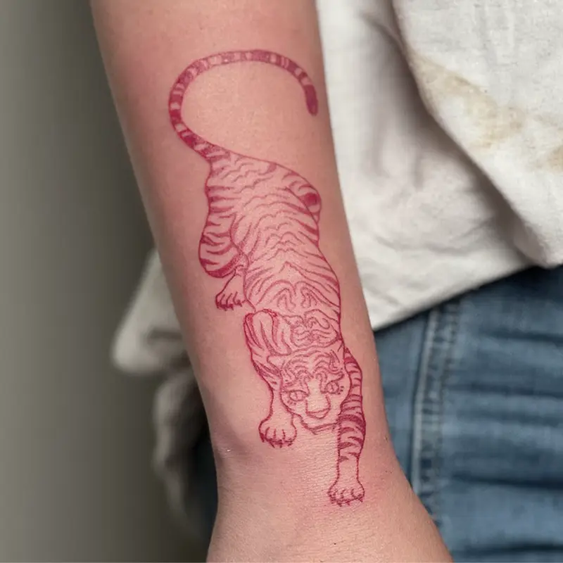 Fine-line tiger tattoo in red ink on forearm — Killer Silver Tattoo Studio