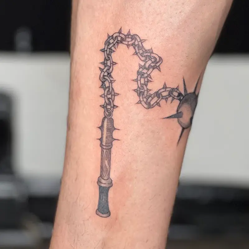 Illustrative black and gray flail weapon tattoo on lower leg — Killer Silver Tattoo Studio