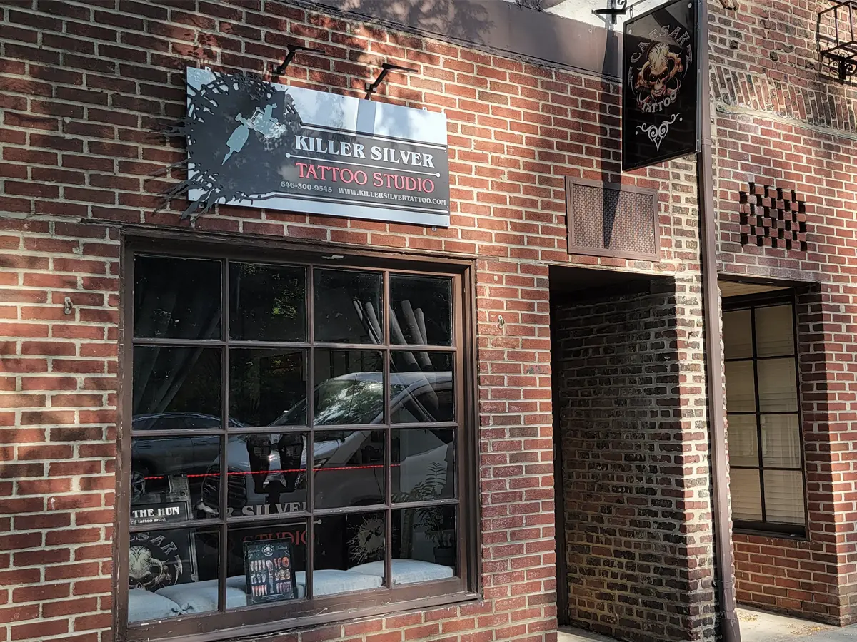 Killer Silver Tattoo and Caesar The Hun signage above the studio entrance in Scarsdale NY