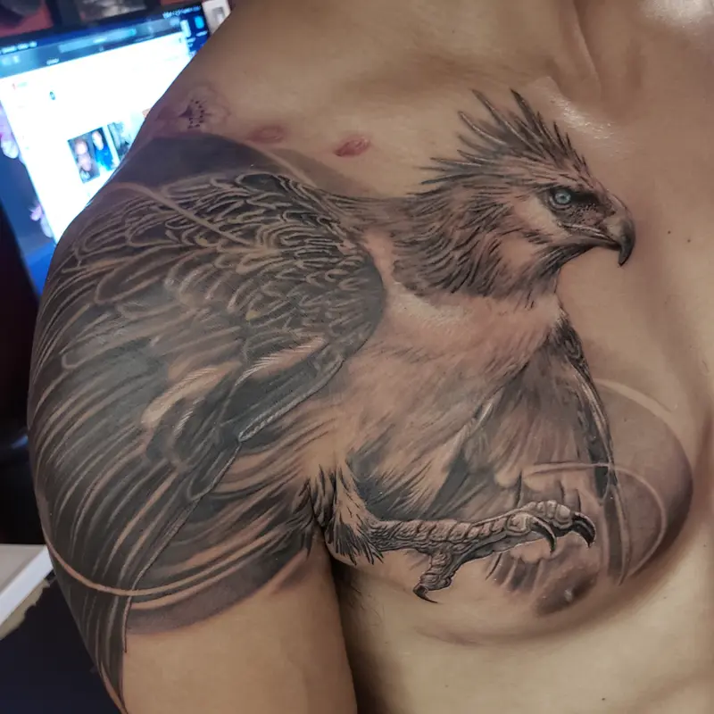 Black and gray realism tattoo of an eagle on the shoulder and chest, by Philipus