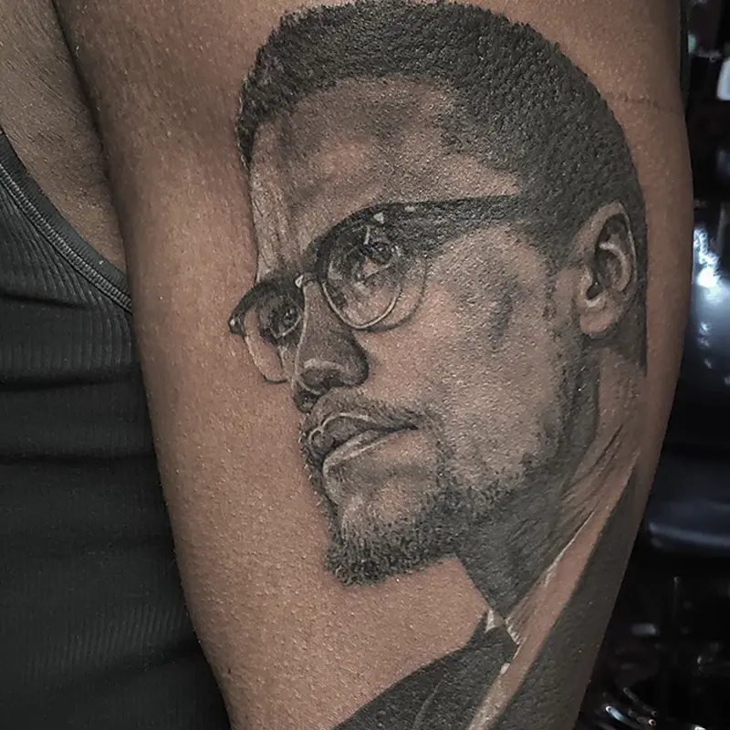 Black and gray realism portrait tattoo of Malcolm X, by Philipus
