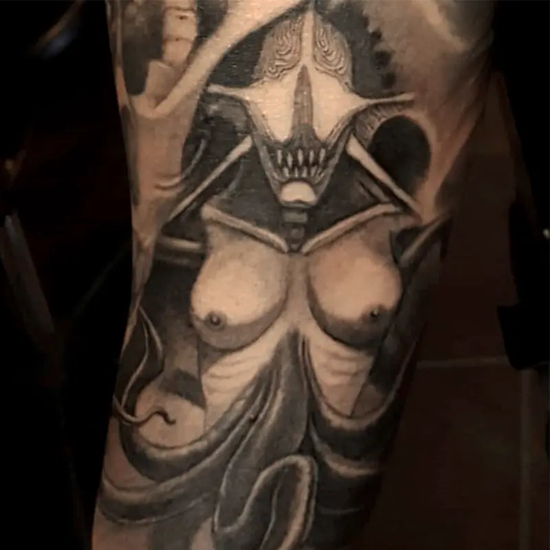 Dark art tattoo of a surreal skeletal demon figure with a nude female torso, by Philipus