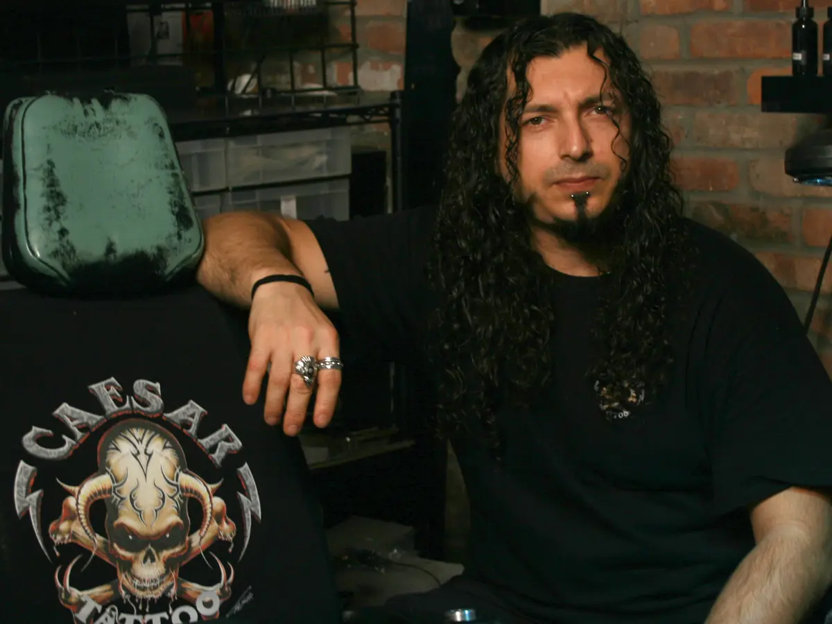 Caesar at Caesar Tattoo, East Village, around 2010, with early Killer Silver test bottles on the shelf