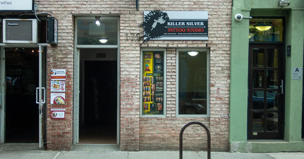 Killer Silver Tattoo Studio sign above a tattoo display window at 172 Avenue B in New York's East Village